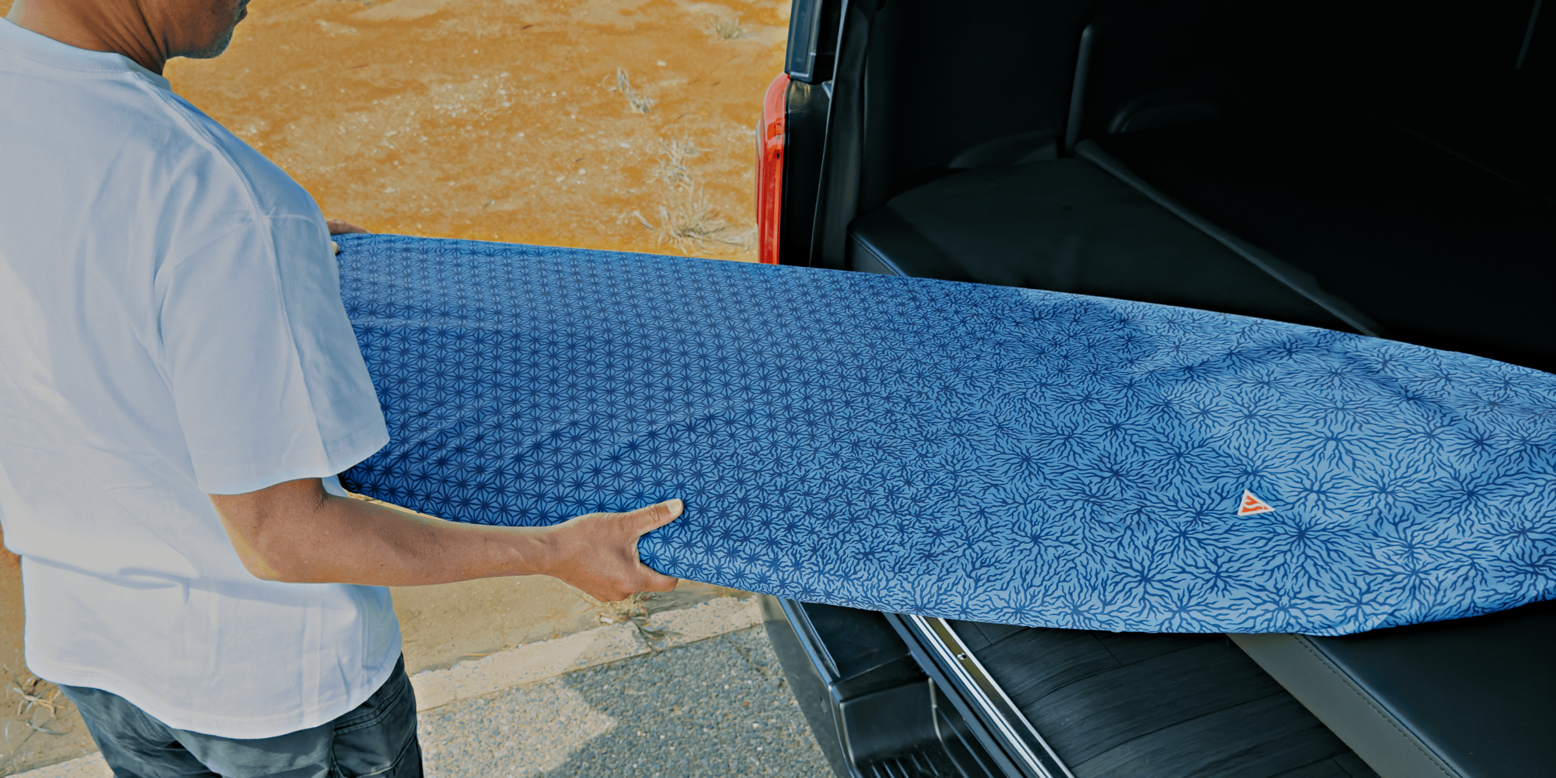 Journey Light サーフボードカバー Indigo を手に持つサーファー — Shign