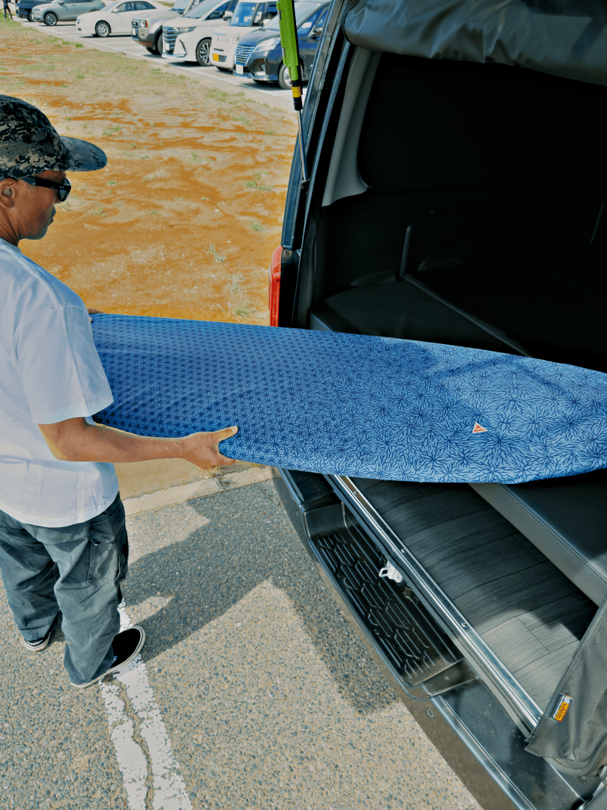 Journey Light サーフボードカバー Indigo を手に持つサーファー — Shign